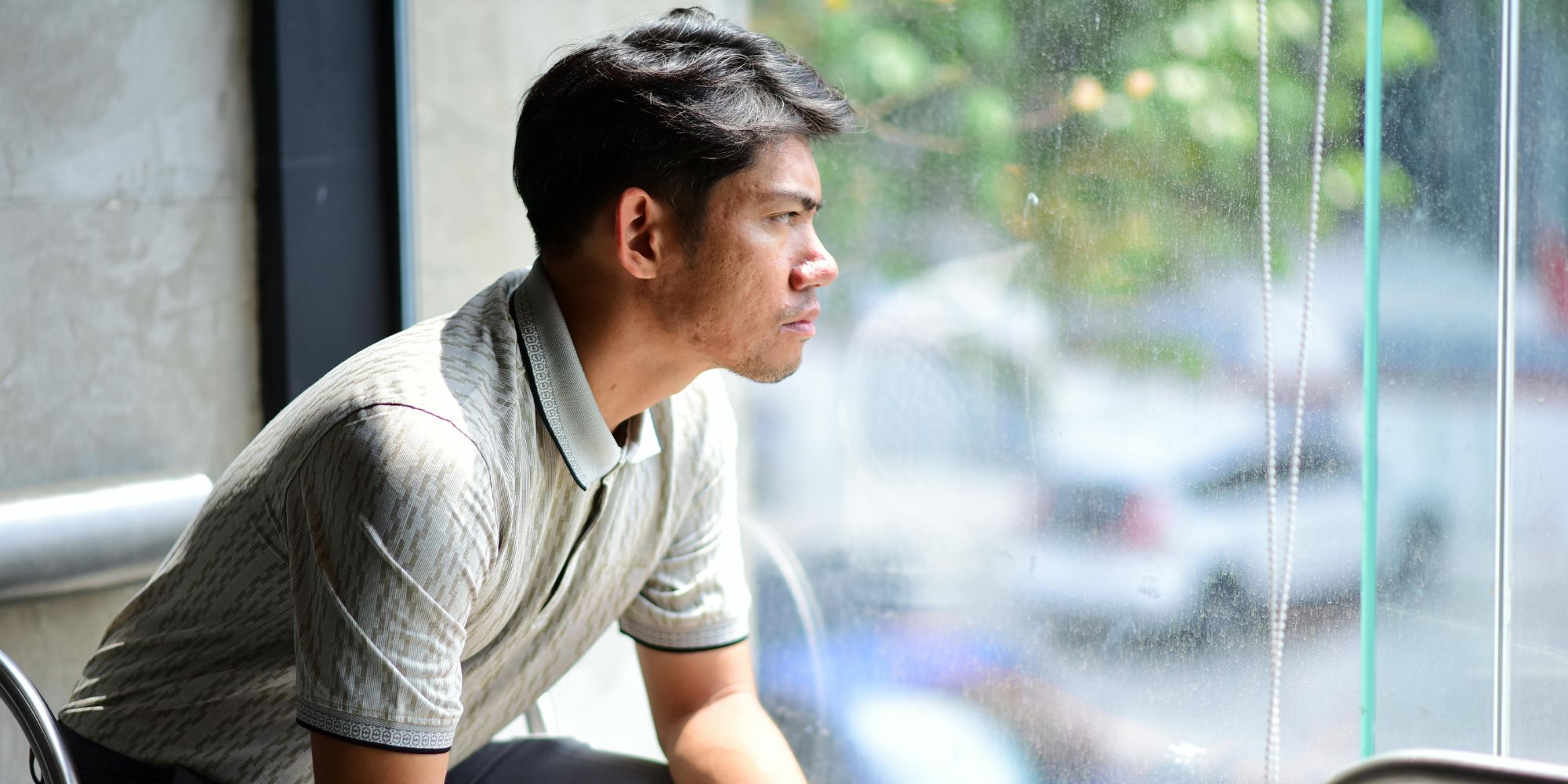 man looking outside window