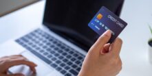 woman looking at laptop and holding credit card