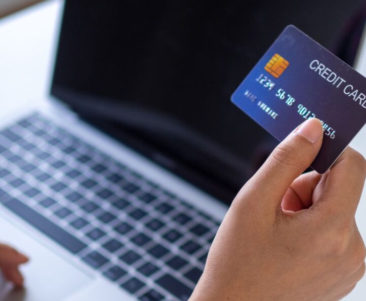 woman looking at laptop and holding credit card
