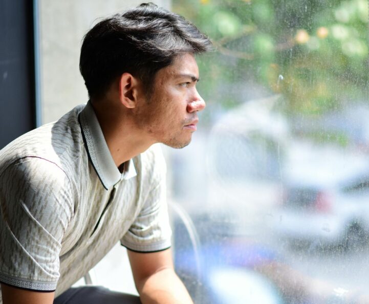man looking outside window